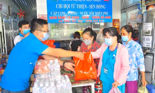 Bạn trẻ hỗ trợ bữa cơm cho bệnh nhân tại bệnh viện ẢNH: HÒA HỘI
