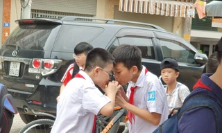 Hai học sinh tại cổng trường Mễ Trì (Hà Nội) vô tư uống chung một cốc nước ngọt