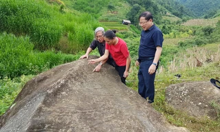 Bí thư xã Đoàn Lao Chải, Lý Thị Thiêm (đứng giữa) thuyết minh về tảng đá cổ cho các vị khách. Ảnh: Xuân Ba 