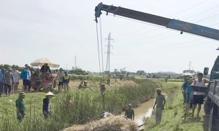 Chiếc xe máy cày chở đầy lúa bị lật xuống mương nước