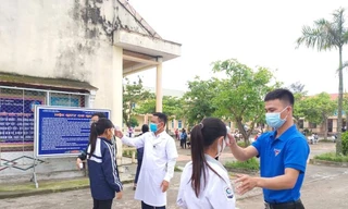 Học sinh được đo thân nhiệt trước khi vào lớp học.