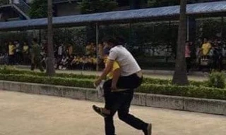 Một công nhân bị ngộ độc được đồng nghiệp cõng đi cấp cứu - Ảnh: Hoàng Long