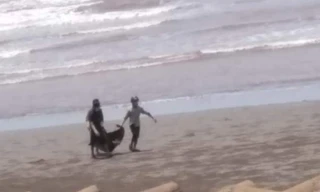 Người dân ven biển Hải Hoà phát hiện và đưa thi thể vào bờ - Ảnh: MĐ