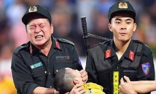 Chiến sỹ cảnh sát cơ động nghiến răng chịu đau để tránh cháu bé cắn vào lưỡi - Ảnh: Hoàng Long