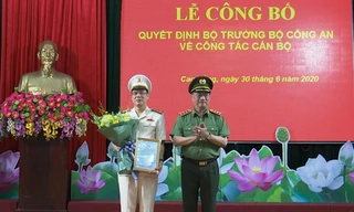 Đại tá Vũ Hồng Quang (bìa trái) nhận Quyết định, hoa chúc mừng từ lãnh đạo Bộ công an .Ảnh: G. Hưng