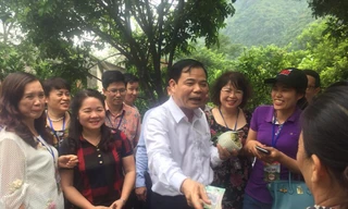 Bộ trưởng Nguyễn Xuân Cường mua na của người dân địa phương. - Ảnh: Hoàng Dự 