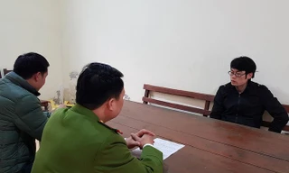 Một đối tượng (bìa phải) trong nhóm sử dụng công nghệ cao để chiếm đoạt tiền trong tài khoản khai báo tại cơ quan công an Lạng Sơn .Ảnh: TL 