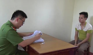 Đối tượng Hoàn (bìa phải) tại cơ quan công an .Ảnh: Minh Anh