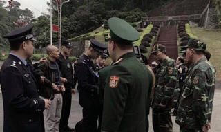 Đối tượng Thọ (thứ 2, bìa trái, đầu trọc) chuẩn bị bàn giao từ Trung Quốc về Việt Nam .Ảnh: Duy Chiến