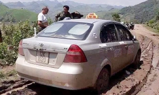 Chiếc xe taxi được tìm thấy ở đoạn đường vắng, sình lầy. Ảnh: TL
