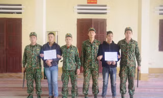 Hai đối tượng Thái và Đại (cầm biển) bị lực lượng biên phòng Tân Thanh bắt giữ khi đưa người qua biên giới trái phép .Ảnh: Duy Chiến 