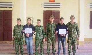 Hai đối tượng Thái và Đại (cầm biển) bị lực lượng biên phòng Tân Thanh bắt giữ khi đưa người qua biên giới trái phép .Ảnh: Duy Chiến 