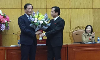 Ông Dương Xuân Huyên (bìa trái) nhận hoa chúc mừng từ lãnh đạo HĐND tỉnh Lạng Sơn. Ảnh: Duy Chiến 