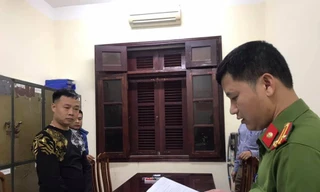 Đối tượng Huynh (bìa trái) tại cơ quan công an. Ảnh: Minh Anh