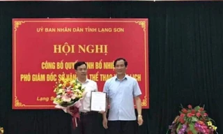 Ông Dương Minh Tuệ (bìa trái) nhận Quyết định và hoa của lãnh đạo tỉnh Lạng Sơn. Ảnh: H.Âu