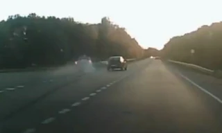 Xe cảnh sát bị ép bay lên rào chắn đường cao tốc