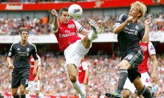 Robin van Persie (giữa) trước sự truy cản của Dirk Kuyt (Liverpool) ở lượt đi.