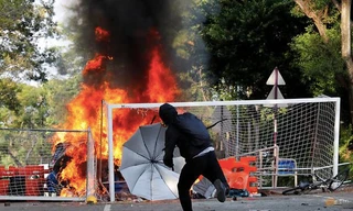 Người biểu tình ném đồ vật vào cảnh sát chống bạo động trong cuộc đối đầu ở ĐH Trung Hoa của Hong Kong. (Ảnh: Reuters)