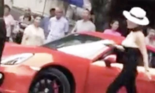 Người phụ nữ đội mũ lái chiếc xe màu đỏ bị ghi hình hành động sỉ nhục và tấn công người đi xe phía sau