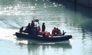 Lực lượng tuần tra Anh vừa cứu được một nhóm người di cư bất hợp pháp bơi trên biển. (Ảnh: EPA)