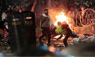 Người biểu tình ném đá vào cảnh sát. (Ảnh: Reuters)