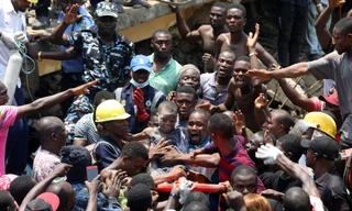 Một trẻ em được cứu thoát khỏi đống đổ nát của tòa nhà bị sập. Ảnh: Reuter