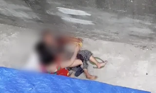 Nạn nhân bị con chó lao vào cắn, xé rách quần áo, nằm quằn quại dưới giữa đường (Ảnh chụp màn hình). 