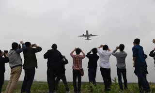 Người dân Trung Quốc thích thú chụp ảnh chiếc máy bay chở khách đầu tiên mang tên Comac C919 do nước này tự sản xuất trong chuyến bay thử nghiệm hôm 5/5 ở sân bay Pudong, Thượng Hải.