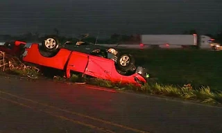 Một chiếc xe ô tô bị lốc xoáy thổi lật vào vệ đường. 