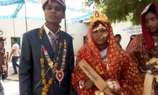 Một cô dâu nhận cây gậy gỗ từ Bộ trưởng trong ngày cưới hôm 29/4.