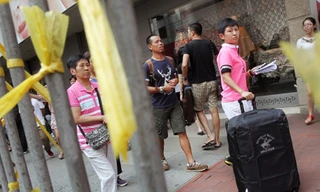 Khách du lịch Trung Quốc đi qua khu vực biểu tình tại Causeway Bay ngày hôm qua (Ảnh: SCMP)