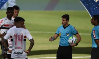 Các trọng tài thông báo cho cầu thủ về việc hoãn trận đấu ngay trước giờ bóng lăn.