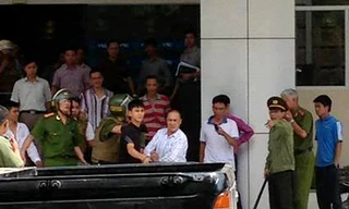 Đối tượng (áo trắng) bị dẫn giải về cơ quan công an để tiếp tục điều tra