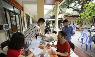 Người dân nhận tiền hỗ trợ của Nhà nước. Ảnh: Như Ý 