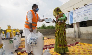 Một nhân viên WFP phát dầu ăn và bột mì cho người dân Pakistan trong tháng 9 vừa qua. Ảnh: WFP 