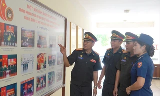 Trung tá Thanih Bounnao (ngoài cùng bên trái) cùng một số thành viên trong đoàn sĩ quan trẻ Lào trao đổi sau một buổi tập huấn tại Đoàn 871, Tổng cục Chính trị QĐND Việt Nam. ẢNH: NGUYỄN MINH