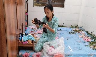 Chị Nguyễn Thị Mắm (xã Vinh Xuân) ngồi thất thần trong căn nhà bị bão số 4 cuốn tốc mái. Ảnh: Ngọc Văn 