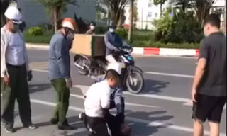 Cán bộ công an xã đứng gọi điện thoại trong khi tài xế taxi bị thương phải vật lộn với tên cướp có hung khí 
