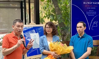 Họa sĩ Lê Thiết Cương (trái) tặng một trong hai bức tranh cho nhà văn Đỗ Bích Thúy. Ảnh: KỲ SƠN