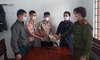 Anh Lê Văn Chung (thứ 2 từ phải sang) bàn giao số tiền nhặt được cho người mất - ảnh Huyền Oanh 