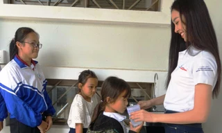 Á hậu Nguyễn Thị Thúy An rót nước cho các trẻ em uống nước tại chương trình Ký túc xá 115, tại xã Ea Dah, huyện Krông Năng, tỉnh Đắk Lắk.