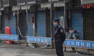 An ninh đứng canh tại khu chợ bán đồ tươi sống ở Vũ Hán, nơi được coi là địa điểm đầu tiên bùng phát đại dịch COVID-19. (Ảnh: Getty Images)