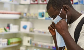 Một người thử đeo khẩu trang y tế tại hiệu thuốc ở Zambia. (Ảnh: AP)