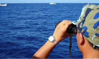 Một cảnh sát biển Việt Nam quan sát các tàu hải cảnh Trung Quốc. (Ảnh: Reuters)