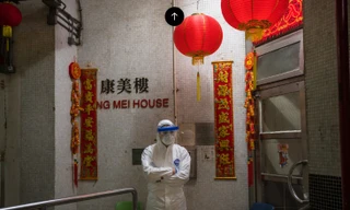 Một cán bộ mặc đồ bảo hộ đứng ngoài tòa nhà đang nghi nCoV lây qua hệ thống đường ống. (Ảnh: Getty Images)