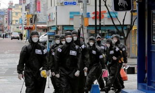 Nhóm binh lính Hàn Quốc đi khử trùng các toà nhà. (Ảnh: Reuters)