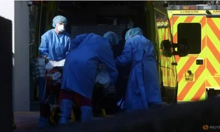 Nhân viên y tế vận chuyển bệnh nhân bên ngoài bệnh viện St. Thomas ở London hôm 26/3. (Ảnh: Reuters)