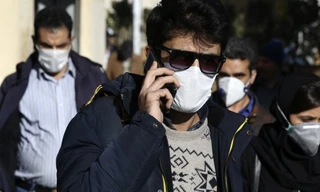 Một người đeo khẩu trang khi đang nói chuyện điện thoại ở khu trung tâm Tehran ngày 2/3. (Ảnh: AP)