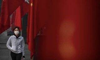 Một phụ nữ đeo khẩu trang khi đi bộ ở Bắc Kinh dịp Tết âm lịch vừa qua. (Ảnh: CNN)