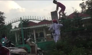 Hình ảnh cán bộ, nhân viên trung tâm tuồn quà từ thiện của trẻ khuyết tật ra ngoài. Ảnh cắt từ clip.